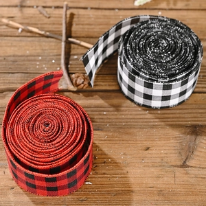 Rustic buffalo plaid ribbons in red, black and white on a dark wooden background