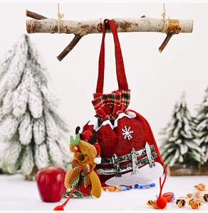 Christmas burlap gift bag with reindeer plush detail hanging on a festive branch