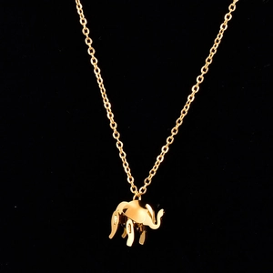 Close-up of polished golden elephant pendant necklace with a fine chain on black background