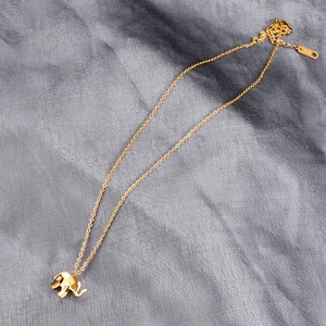 Detailed view of golden elephant pendant necklace with K18 engraved metal hallmark tag