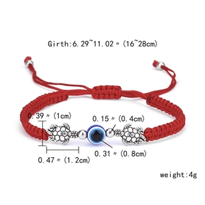 Detailed view of red woven evil eye bracelet with silver turtle and glass bead measurements