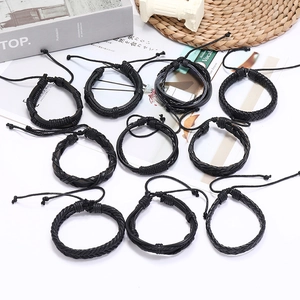 Set of 10 black braided leather bracelets with adjustable ties on a white background