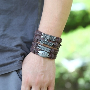 Détail de l'ensemble de bracelets en cuir tressé vintage avec pendentifs moto et plaque believe