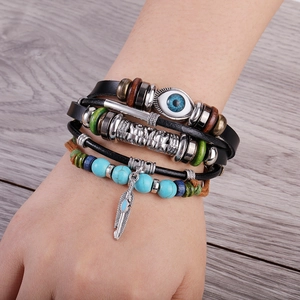 Detail view of multi-layer leather bracelet with turquoise beads and feather charm
