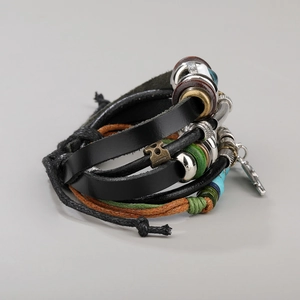 Detailed view of multilayer leather bracelet with metal beads and key charm pendant