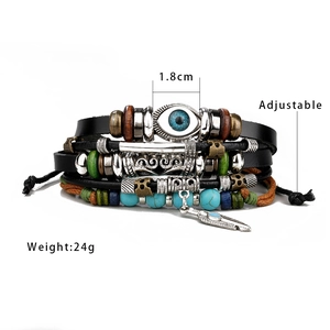 Detail of multilayer leather bracelet with blue evil eye charm and feather pendant