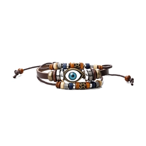 Detailed close-up of multilayer leather bracelet with evil eye bead and ethnic wood beads