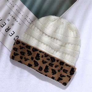 Detailed knit texture of a beige beanie with leopard print cuff on a magazine background