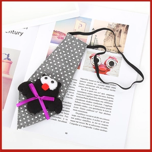 Close-up of Halloween pet tie with grey polka dots and black bat doll on magazine