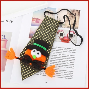 Detail of Halloween necktie with orange plush character on black gold polka dot fabric