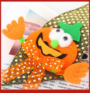 Close-up of Halloween headband featuring orange felt pumpkin with sequins and polka dot bow