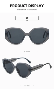 Détail de lunettes de soleil rondes en plastique avec branches larges et monture grise