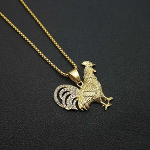 Macro shot of gold-plated rooster pendant with sparkling crystal inlay on box chain