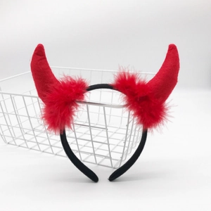 Detail of red devil horn headband with black feather trim for holiday parties