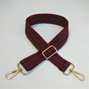 Close-up of red and green woven adjustable strap with gold metal buckles and chevron pattern