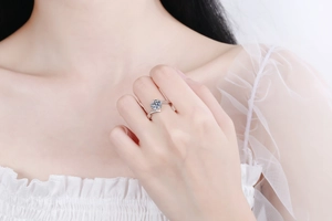 Detailed view of a silver snowflake ring with a 1 carat round moissanite on a finger