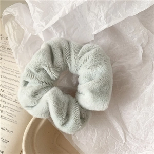Close-up of soft fluffy faux fur scrunchie in light grey blue for autumn winter
