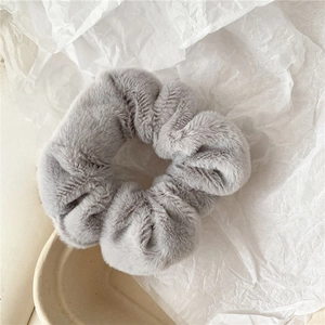 Close-up of soft grey plush scrunchie made of faux rabbit fur for autumn winter
