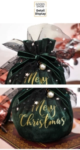 Detail of dark green velvet Christmas gift bag with golden Merry Christmas print and pearl bow