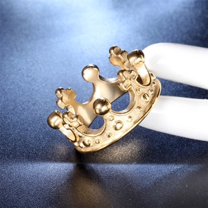 Macro shot of a golden crown ring made of stainless steel displayed on a white model finger