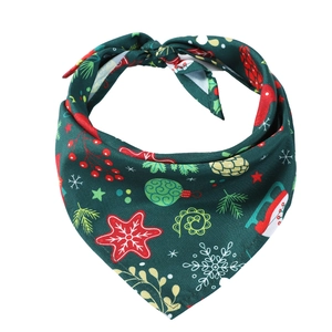 Detail of Christmas pet bandana with festive prints on green knit fabric for dogs