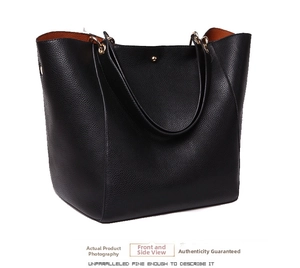 Detail of black pebbled leather tote bag featuring contrast orange lining and gold studs