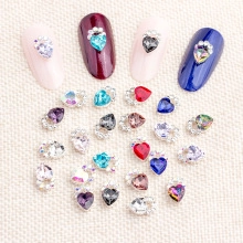 Close-up of heart-shaped crystal nail charms in various colors on linen background