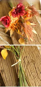 Detail of autumn-themed faux flower bouquet with roses and daisies on wood background