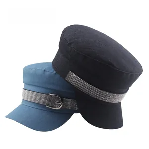Detailed texture of denim navy caps with rhinestone bands and metal buckle accents