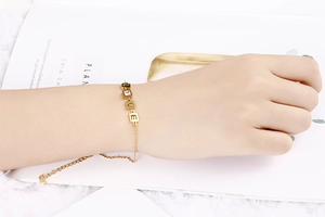 Dettaglio di un bracciale LOVE regolabile in oro con zirconi sul polso