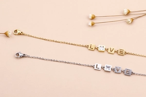 Dettaglio del bracciale LOVE regolabile con finitura dorata e pietra di zircone scintillante