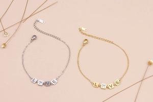 Dettaglio di bracciali LOVE regolabili in oro e argento con brillanti pietre di zircone