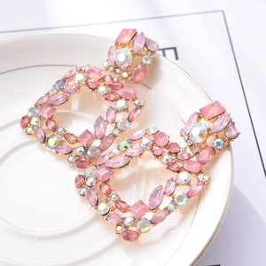 Detailed close-up of geometric square crystal earrings with pink and aurora crystals