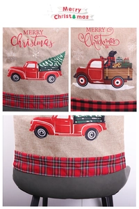 Close-up of linen Christmas chair cover with red truck and festive tree details