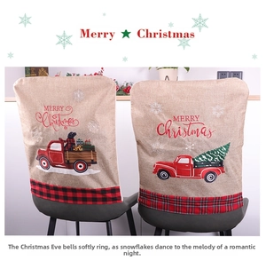 Detail of linen Christmas chair covers with red truck motif and plaid pattern borders