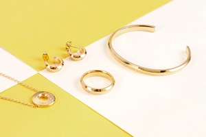 Dettaglio del set di gioielli dorati incisi 'MY LOVE' con collana, anello e bracciale