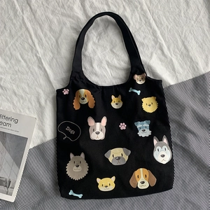 Detailed pattern of cartoon dog illustrations on a black canvas tote bag for daily use