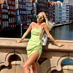 Detail of light green halter neck dress featuring side ruching and a high slit design