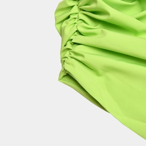 Detailed close-up showing the pleated fabric texture and neon green stitching details