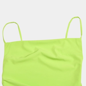 Detail of neon green satin dress featuring spaghetti straps and flat neckline design