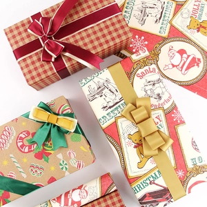 Assorted vintage Christmas gift wrapping paper rolls with festive ribbons in a flat lay view