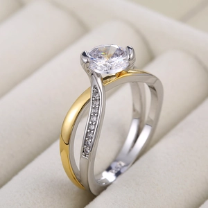 Vue macro d'une bague de fiançailles bicolore croisée avec zircon rond et serti à quatre griffes