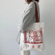 Détail du sac fourre-tout blanc avec imprimé Usagi rouge et bandoulière rouge assortie