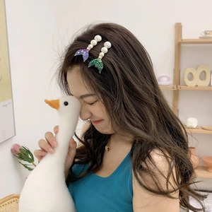 Détail de pinces à cheveux sirène violettes et vertes avec perles sur un modèle