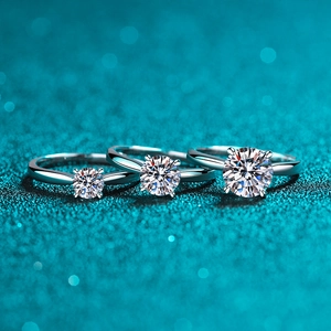 Three classic S925 sterling silver moissanite rings in different carat sizes on a blue background