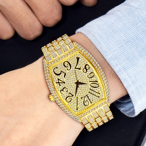 Detail of luxury iced-out tonneau watch on wrist with business attire background