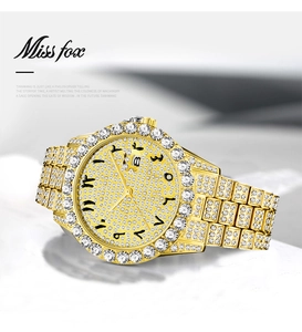 Close-up of luxury gold-tone watch featuring full crystal pavé setting and date window
