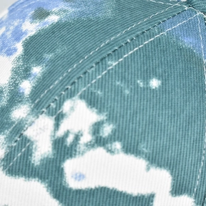 Close-up of tie-dye cotton fabric with twill texture and neat white stitching on hat