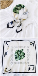 Detail of elegant silk square scarf with green botanical print and abstract patterns