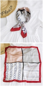 Detail of geometric pattern silk scarf showing red border and mixed print textures